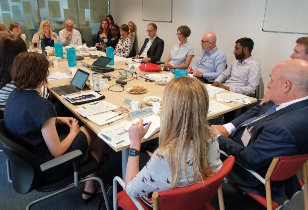 Social Security Advisory Committee members in discussion with stakeholders around a table.